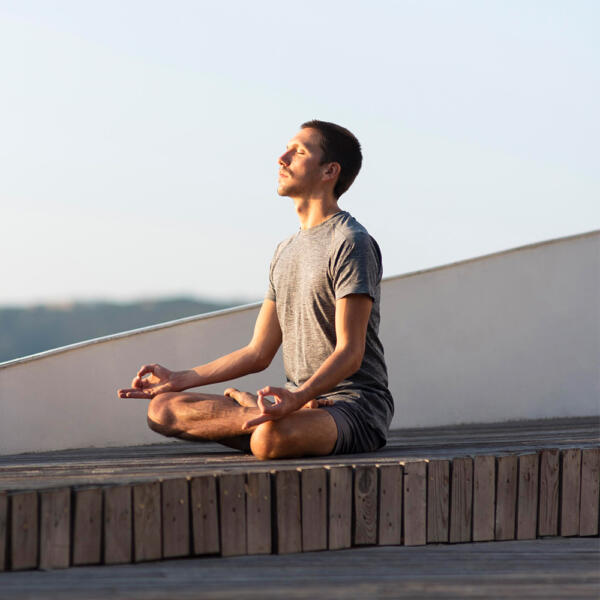 man meditating outside near beach